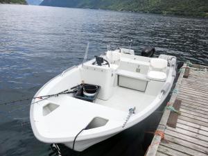 a white boat tied to a dock on a lake at Holiday Home Njord by Interhome in Arnefjord