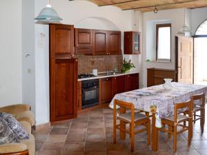 una cocina con armarios de madera y una mesa con sillas. en Holiday Home Gabriele by Interhome, en Picciano