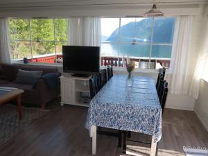 a living room with a table with a television and a couch at Holiday Home Njord by Interhome in Arnefjord +17 photos