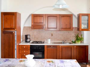 una cocina con armarios de madera y fregadero en Holiday Home Gabriele by Interhome, en Picciano