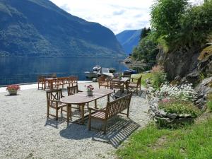 a table and chairs with a view of a lake at Apartment Fagerdalsnipi - FJS609 by Interhome in Arnefjord