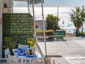 a table with blue dishes on a balcony with the ocean at Apartment Casa Fidalma by Interhome in Costarainera
