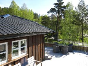 a log cabin with a patio and a table and chairs at Holiday Home Solfridbu - SOW070 by Interhome in Øyuvstad