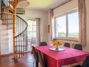 comedor con mesa y mantel rojo en Holiday Home Verdin by Interhome, en Malcesine