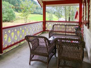 dos sillas de mimbre y una mesa en un porche en Chalet Skogstjerna - FJS085 by Interhome, en Viksdalen