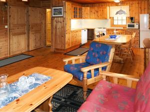una cucina e una sala da pranzo con tavolo e sedie di Chalet Skogstjerna - FJS085 by Interhome a Viksdalen