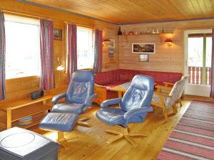 a living room with a table and chairs and a couch at Chalet Espetveit by Interhome in Hornnes +10 photos
