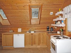eine Küche in einem Blockhaus mit einer Spüle und einem Herd in der Unterkunft Holiday Home Tufto by Interhome in Lunde + 6 Fotos