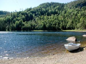 a boat sitting on the shore of a lake at Holiday Home Haven - SOO334 by Interhome in Birkeland