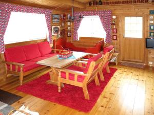 ein Wohnzimmer mit einem roten Sofa und einem Tisch in der Unterkunft Chalet Fjellbris - FJS106 by Interhome in Holsen