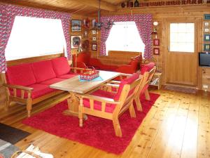 a living room with a red couch and a table at Chalet Fjellbris by Interhome in Holsen +10 photos