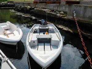 two white boats tied to a dock in the water at Holiday Home Kvamsvika - FJS560 by Interhome in Kvammen