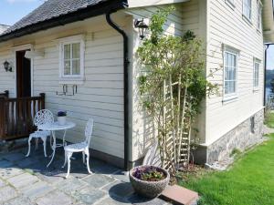 un patio con 2 sedie e un tavolo di fronte a una casa di Holiday Home Kvamsvika - FJS560 by Interhome a Kvammen