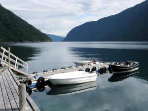dos barcos están atracados en un muelle en un lago en Holiday Home Heimdall - FJS604 by Interhome, en Arnefjord