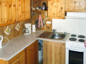 a kitchen with wooden cabinets and a sink at Holiday Home Hammaren by Interhome in Kaupanger +6 photos