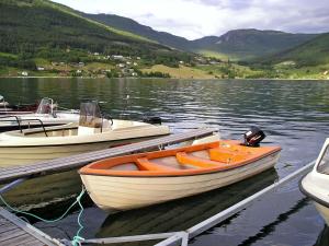 drei Boote liegen an einem Steg an einem See in der Unterkunft Holiday Home Turken by Interhome in Kaupanger