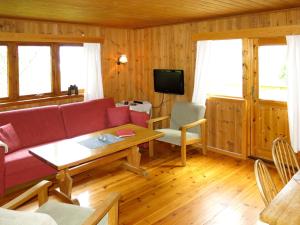 salon z czerwoną kanapą i stołem w obiekcie Holiday Home Turken - FJS767 by Interhome w mieście Kaupanger
