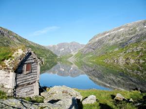 an old house sitting next to a mountain lake at Holiday Home Lauvavatnet - FJS087 by Interhome in Viksdalen