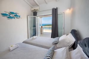 a bedroom with two beds and a view of the ocean at Waterfalls in Gaios +41 photos