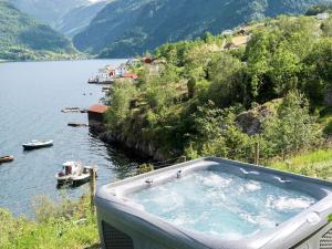 a bath tub sitting on the side of a lake at Holiday Home Odin - FJS608 by Interhome in Arnefjord