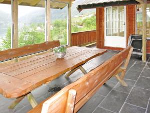 eine Holzbank auf der Veranda eines Hauses in der Unterkunft Holiday Home Odin - FJS608 by Interhome in Arnefjord