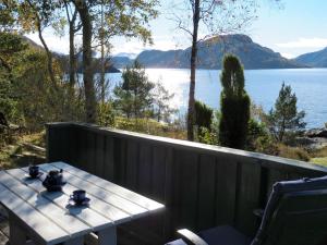 una mesa en un balcón con vistas al lago en Holiday Home Hjartnesvika - FJH662 by Interhome, en Hjartåker