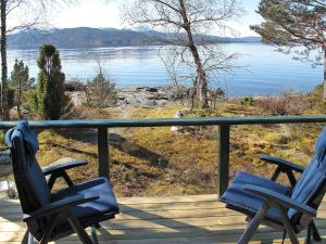 2 sillas en una terraza con vistas al agua en Holiday Home Hjartnesvika - FJH662 by Interhome, en Hjartåker