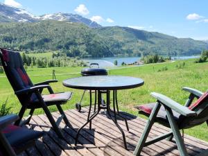 a table and chairs on a deck with a tea kettle on it at Chalet Haukedalspanorama - FJS257 by Interhome in Holsen