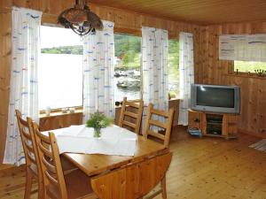 uma sala de jantar com uma mesa e uma televisão em Holiday Home Nanna - FJS130 by Interhome em Hyllestad
