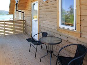 einen Tisch und Stühle auf der Veranda einer Hütte in der Unterkunft Apartment Gurevika - FJH663 by Interhome in Nordhuglo