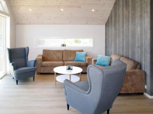 ein Wohnzimmer mit einem Sofa, einem Tisch und Stühlen in der Unterkunft Apartment Gurevika - FJH663 by Interhome in Nordhuglo