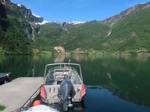 a boat parked on a dock on a lake at Holiday Home Indresfjord - FJS615 by Interhome in Åse