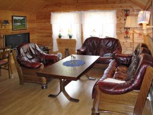 un soggiorno con mobili in pelle e tavolo di Holiday Home Indresfjord - FJS615 by Interhome ad Åse