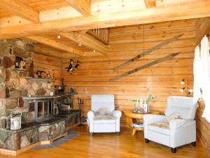 a living room with a stone fireplace and two chairs at Holiday Home Steinbu by Interhome in Øyuvstad