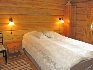 a bedroom with a bed with wooden walls and two lights at Holiday Home Steinbu by Interhome in Øyuvstad