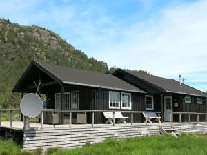 a black house with a large porch and a hill at Holiday Home Torebu - SOW108 by Interhome in Øyuvstad