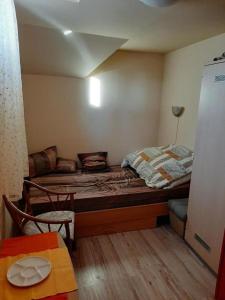 um pequeno quarto com uma cama e uma mesa em Krémer Vendégház em Harkány