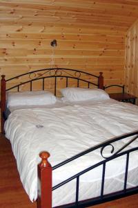 Bett in einem Zimmer mit einer Holzwand in der Unterkunft Chalet Hardangerrorbu - FJH411 by Interhome in Tjoflot