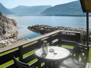 a table with a vase on it next to a lake at Chalet Hardangerrorbu - FJH411 by Interhome in Tjoflot