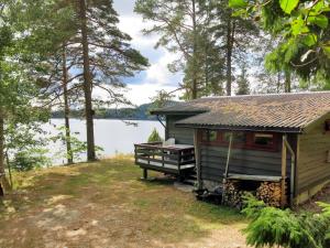 eine Hütte mit einer Bank neben einem See in der Unterkunft Chalet Vigdisheimen - SOO225 by Interhome in Rykene