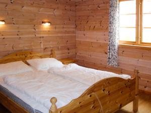 een houten bed in een kamer met een raam bij Chalet Eiknes - FJH412 by Interhome in Tjoflot