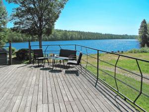 a wooden deck with a table and chairs next to a lake at Holiday Home Hoka Villan - B in Asarum