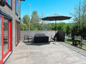 a patio with a table and an umbrella at Holiday Home Hoka Villan - B in Asarum