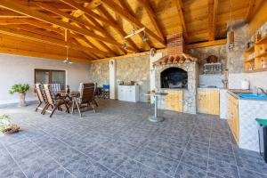 a large kitchen with a table and a fireplace at TOMIC A MAZURANICA in Novi Vinodolski