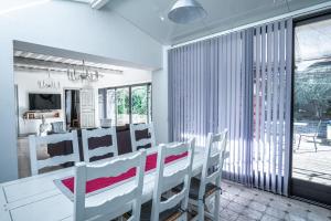 Un comedor con una mesa y sillas blancas. en Gîte tout confort - jardin et piscine chauffée, en Lagnes 20 fotos más