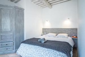 Un dormitorio con una cama con un osito de peluche encima. en Gîte tout confort - jardin et piscine chauffée, en Lagnes