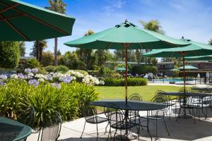 un groupe de tables et de chaises avec parasols dans l'établissement Ramada by Wyndham Sunnyvale/Silicon Valley, à Sunnyvale