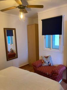 a bedroom with a bed and a chair and a mirror at Casa Linda in Guaro