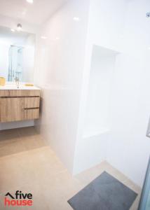 uma casa de banho branca com um lavatório e um espelho em Five House 14B no Porto