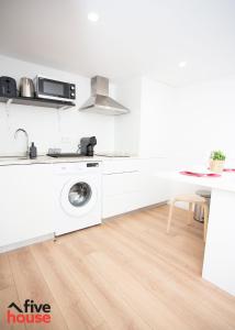 uma cozinha branca com uma máquina de lavar roupa em Five House 14B no Porto